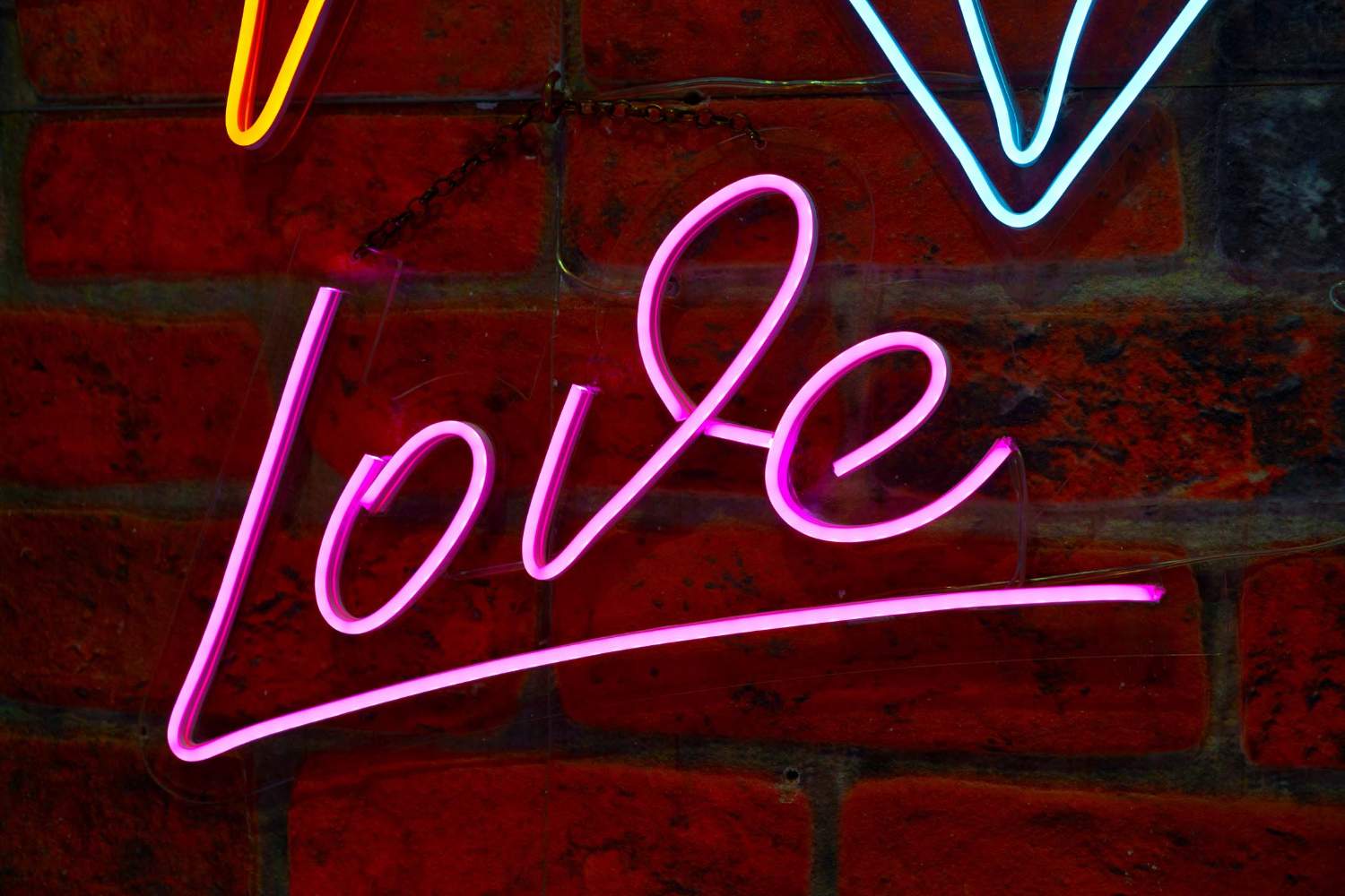 Love Letters neon sign on a brick wall.